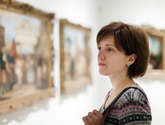 Young woman looking pictures in  museum